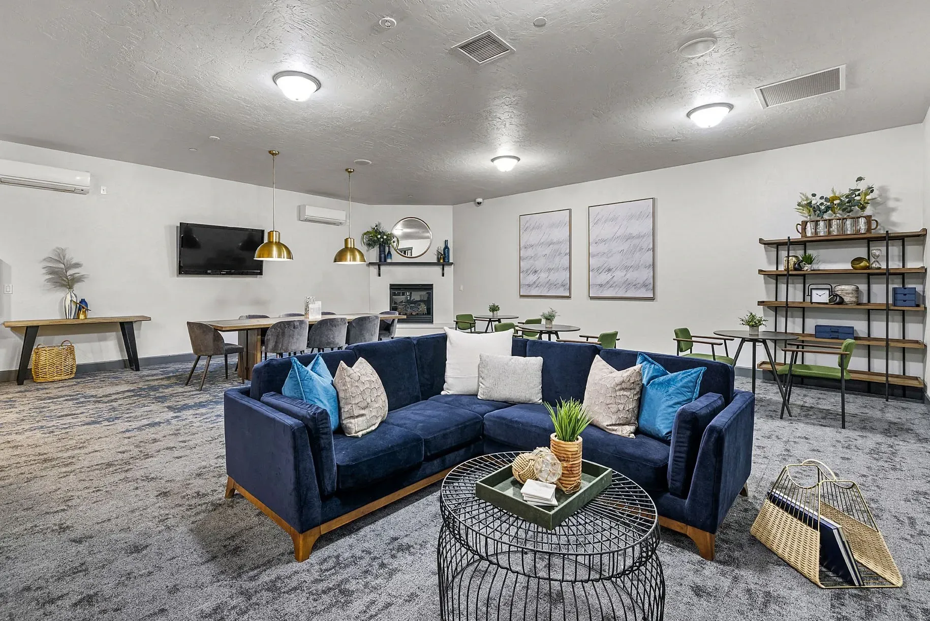Lobby with a navy blue sectional sofa, coffee table, dining area, and shelving unit.