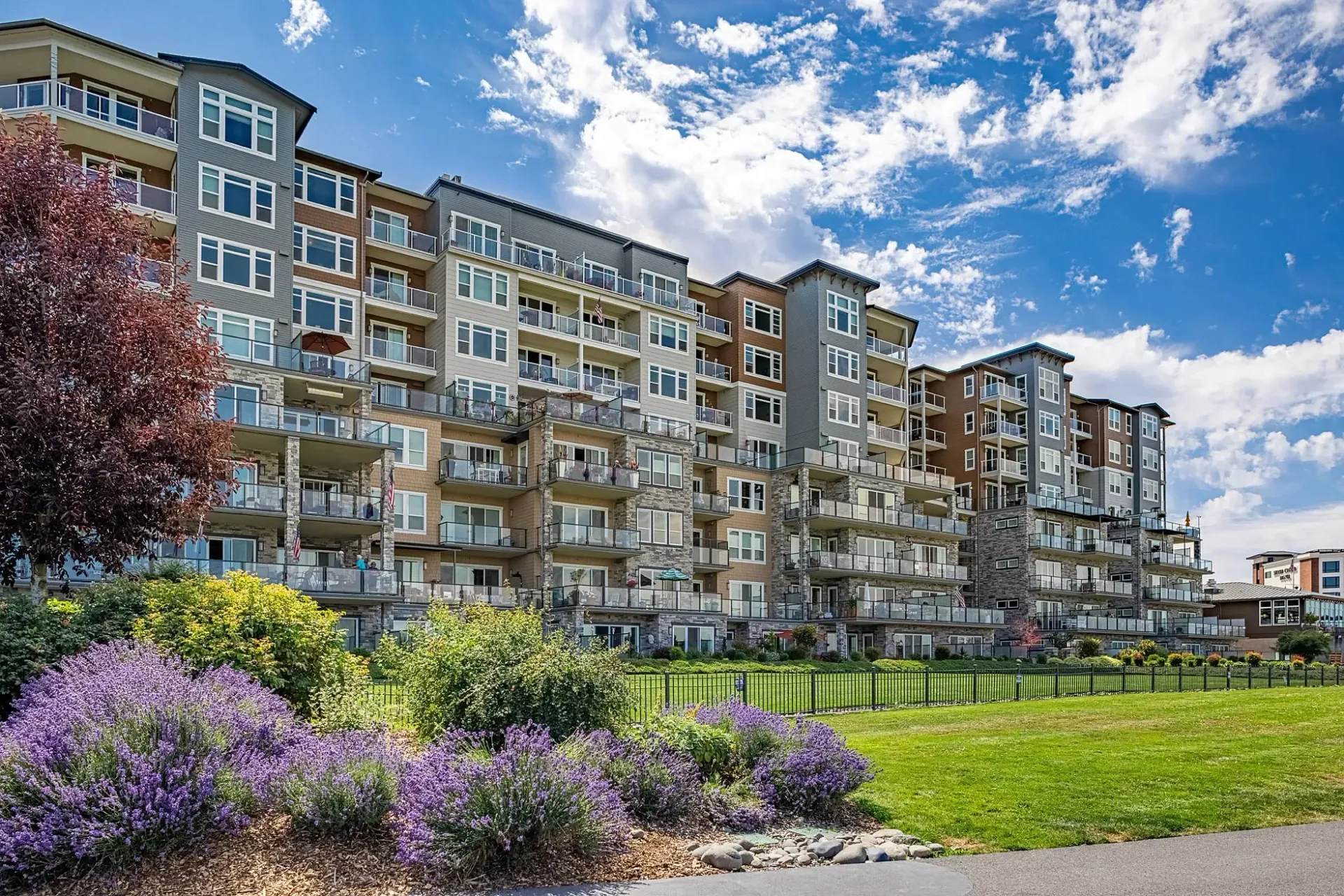 Exterior view of a modern apartment building with balconies and lush landscaping.