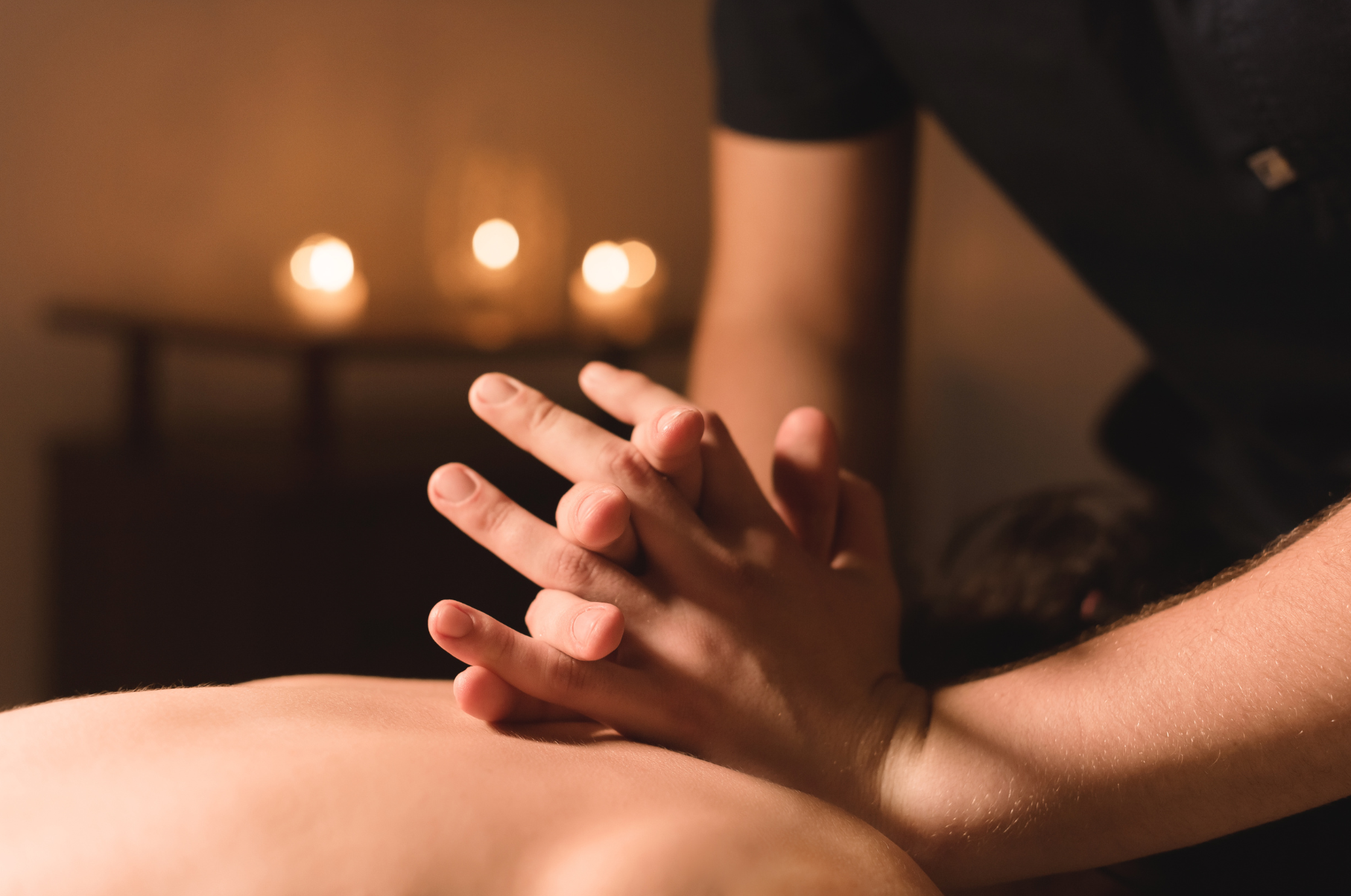 A woman is giving a massage to another woman in a room.