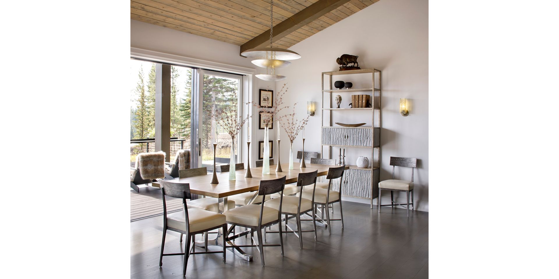 A dining room with a long table and chairs and a large window.