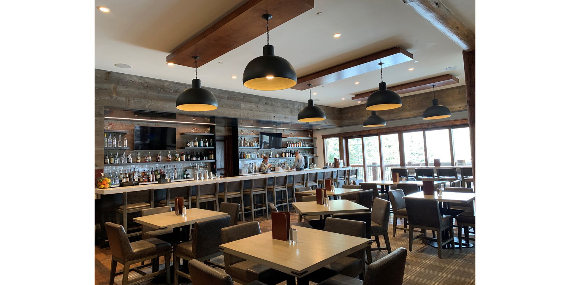 A restaurant with tables and chairs and a bar.