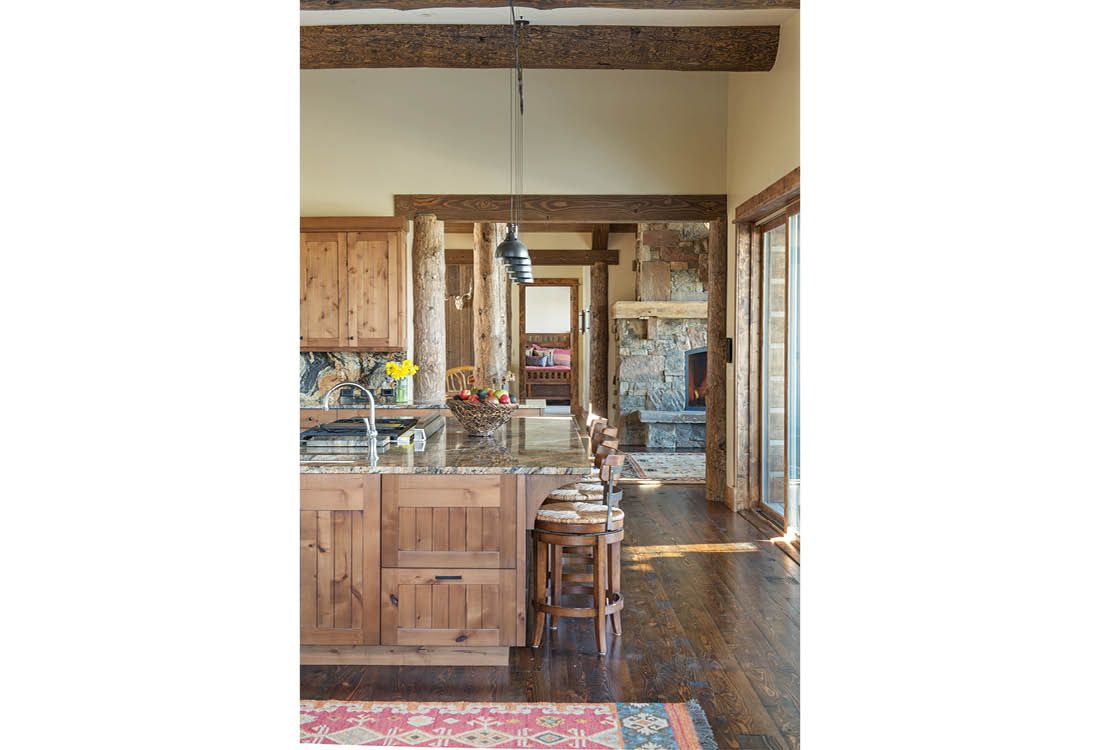 A kitchen with wooden cabinets and granite counter tops in a house.
