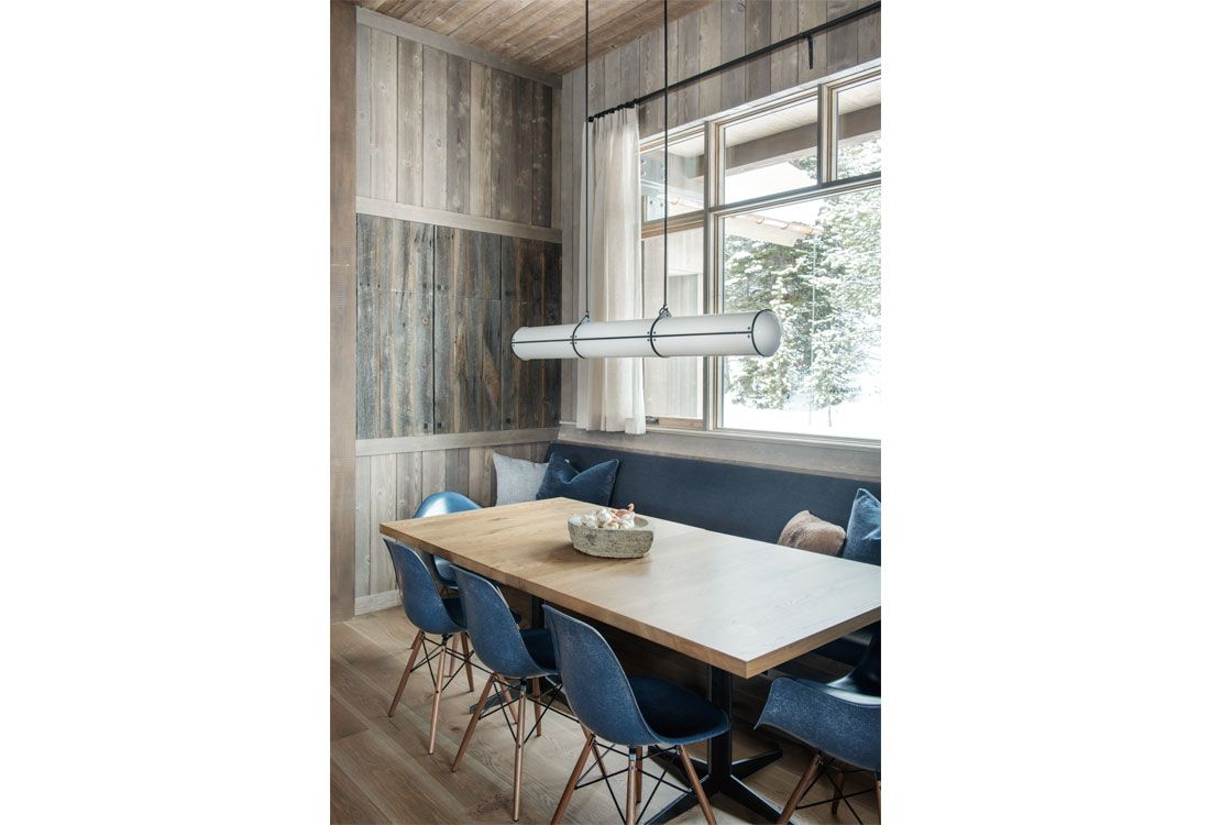 A dining room with a table and chairs and a window.