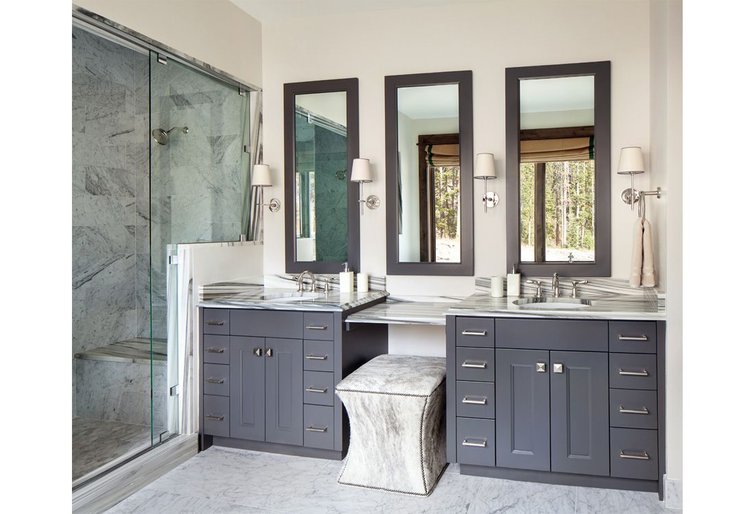 A bathroom with two sinks and three mirrors