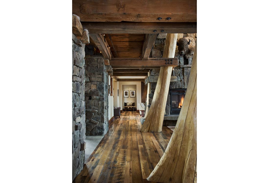 A hallway in a house with wooden floors and a fireplace.