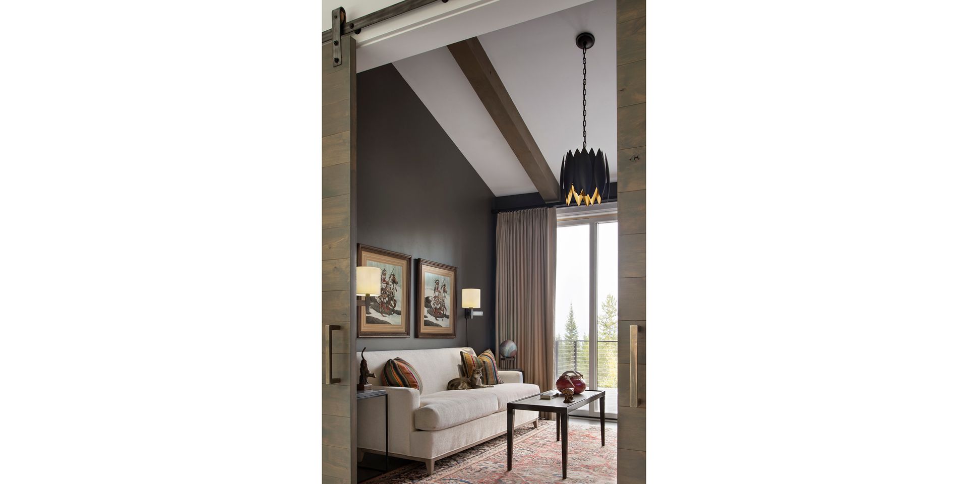 A living room with a couch , coffee table , and sliding barn doors.