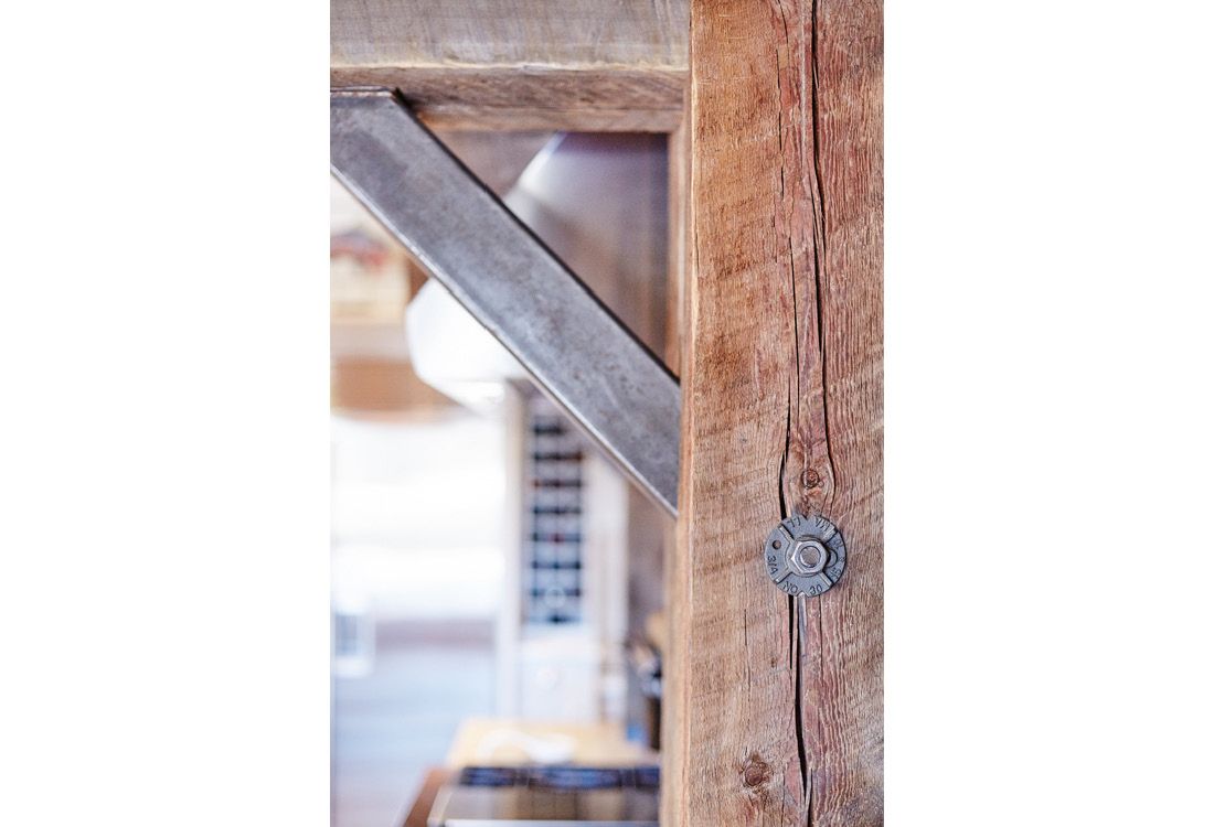 A close up of a wooden post with a metal bracket attached to it.
