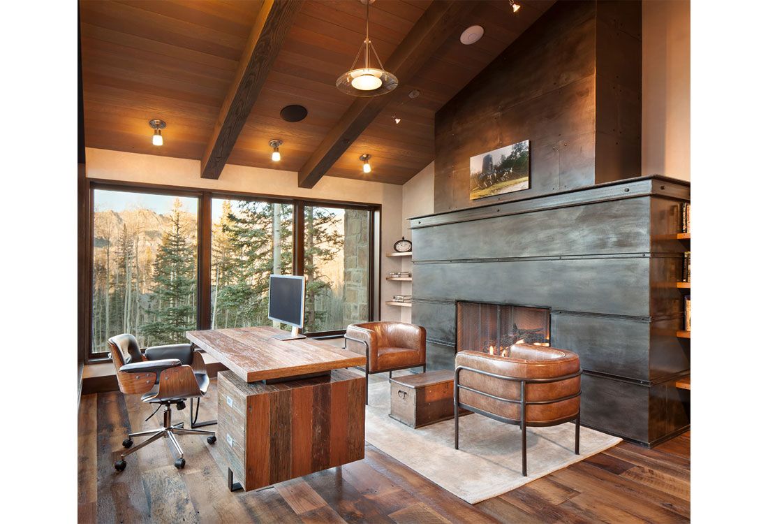 A living room with a fireplace and a desk with a computer on it.