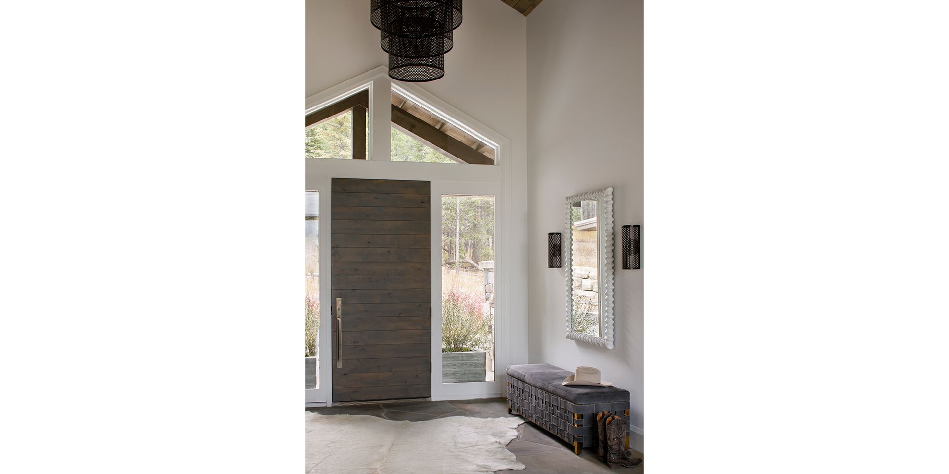 A hallway with a large door and a bench in front of it.