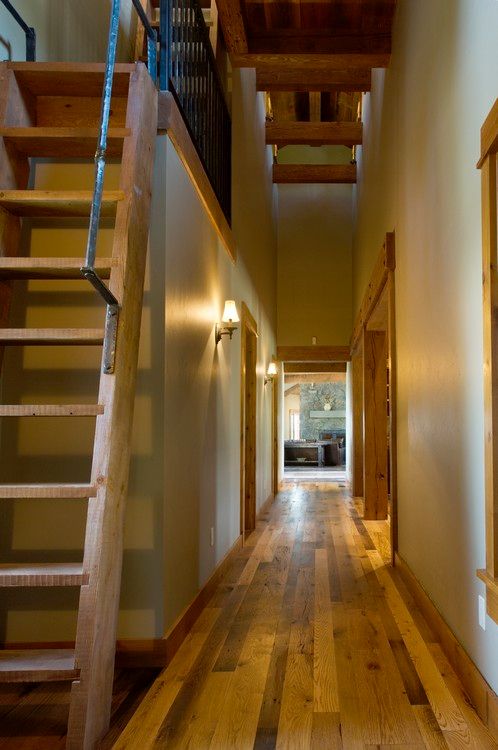A hallway with wooden floors and stairs leading up to the second floor