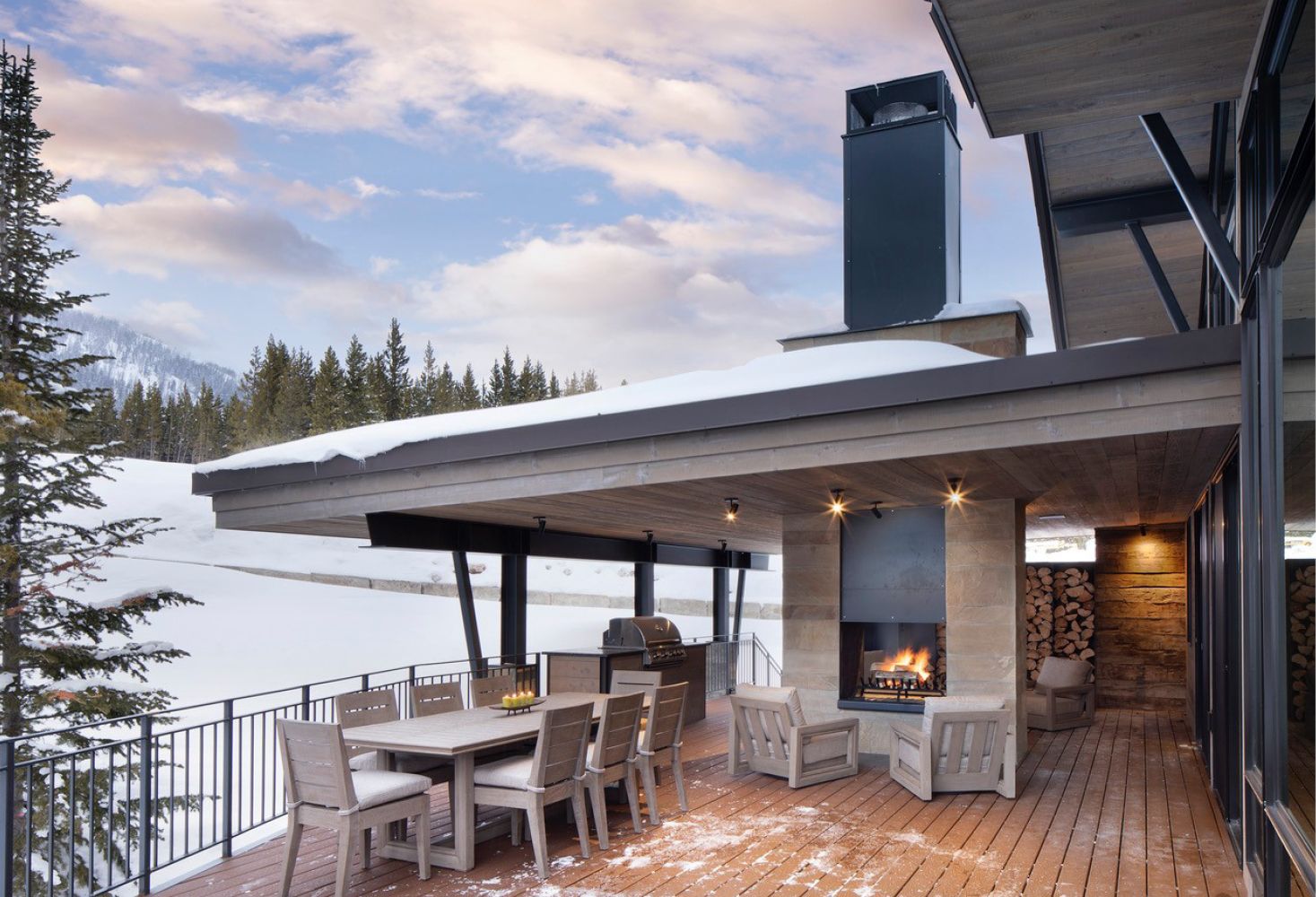 A patio with a table and chairs and a fireplace