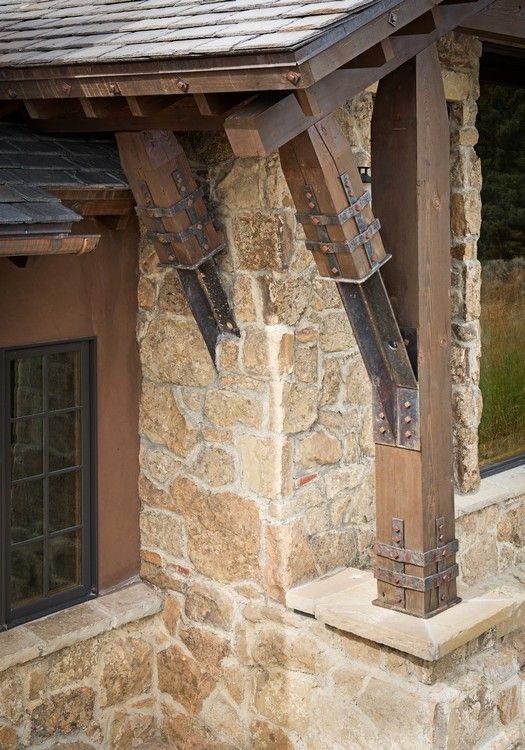 A close up of a stone wall with wooden beams and a window.