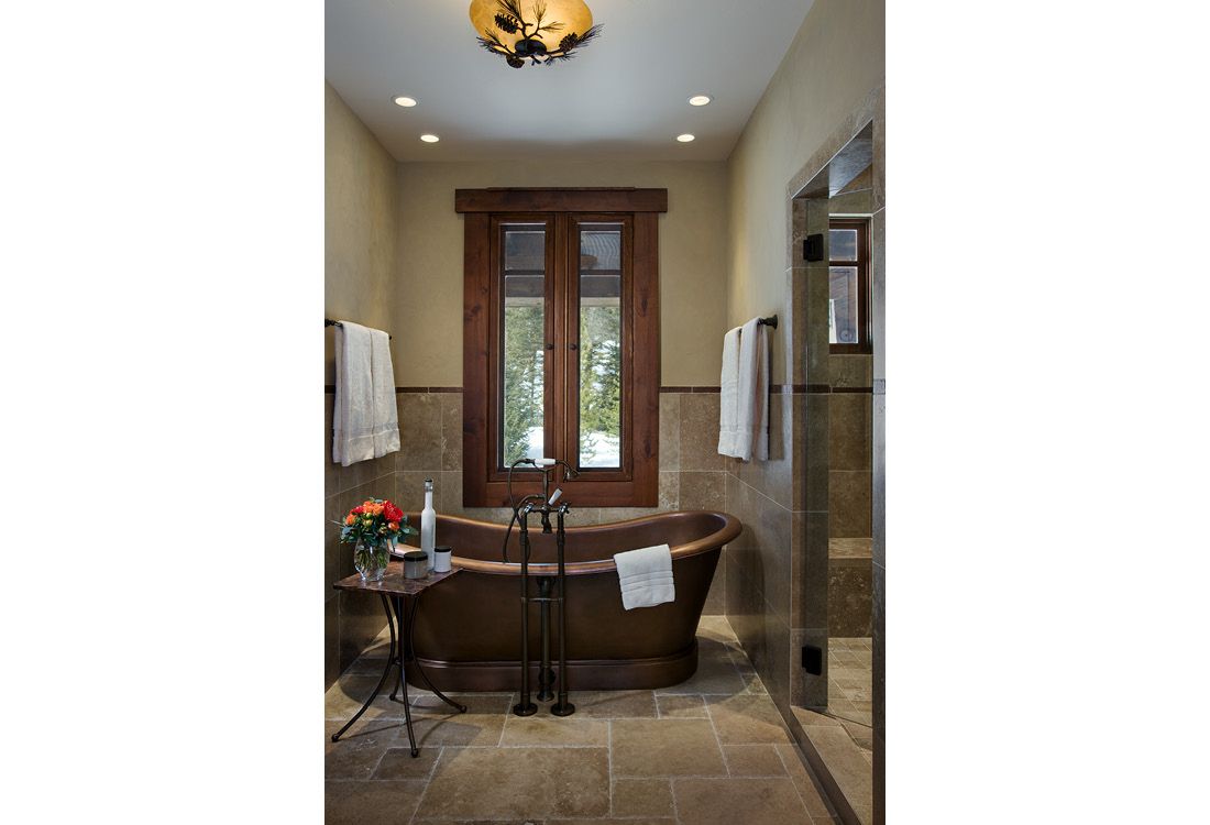 A bathroom with a claw foot tub and two windows