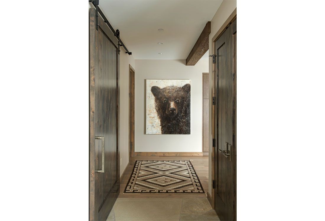 A hallway with a painting of a bear on the wall.