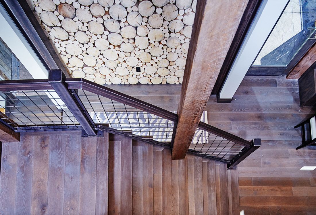 An aerial view of a wooden staircase with a metal railing.
