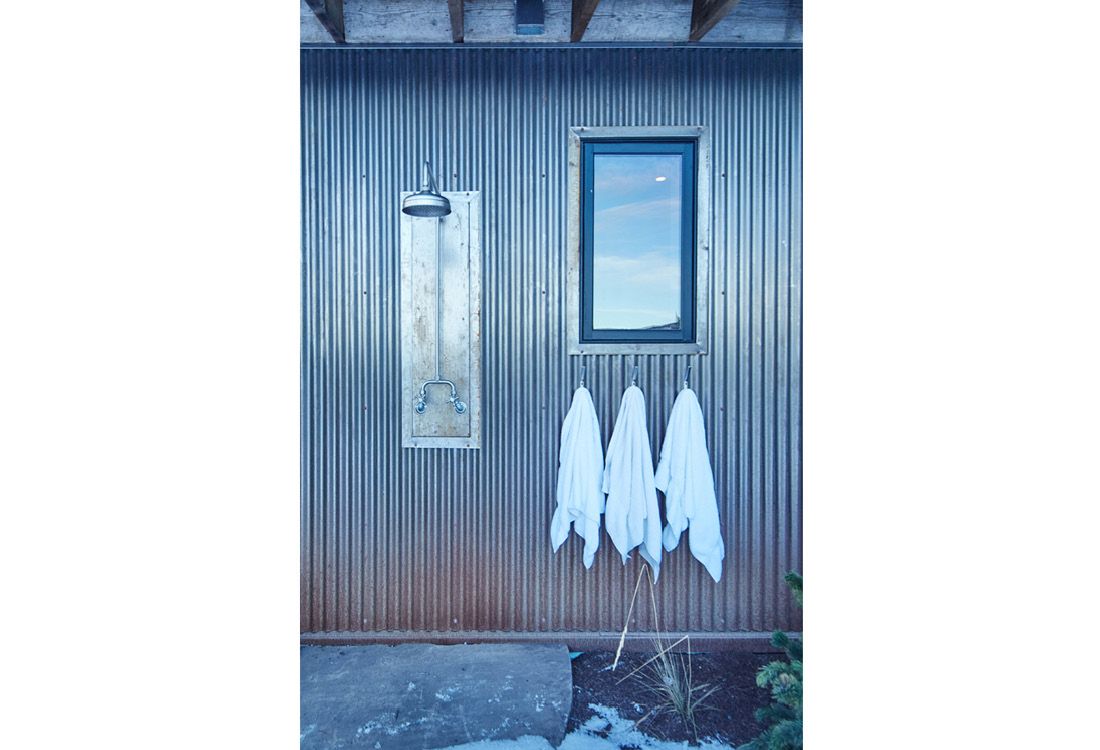 Three towels are hanging on a metal wall next to a window.