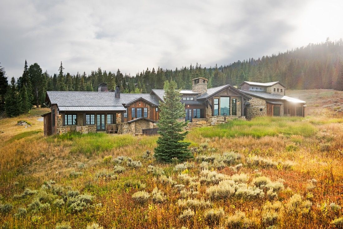 A large house is sitting in the middle of a grassy field.