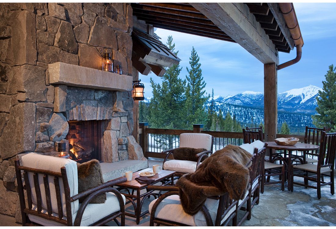 A patio with a fireplace and mountains in the background