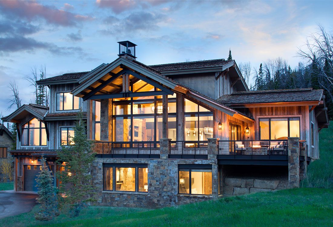 A large house with a lot of windows is sitting on top of a hill.