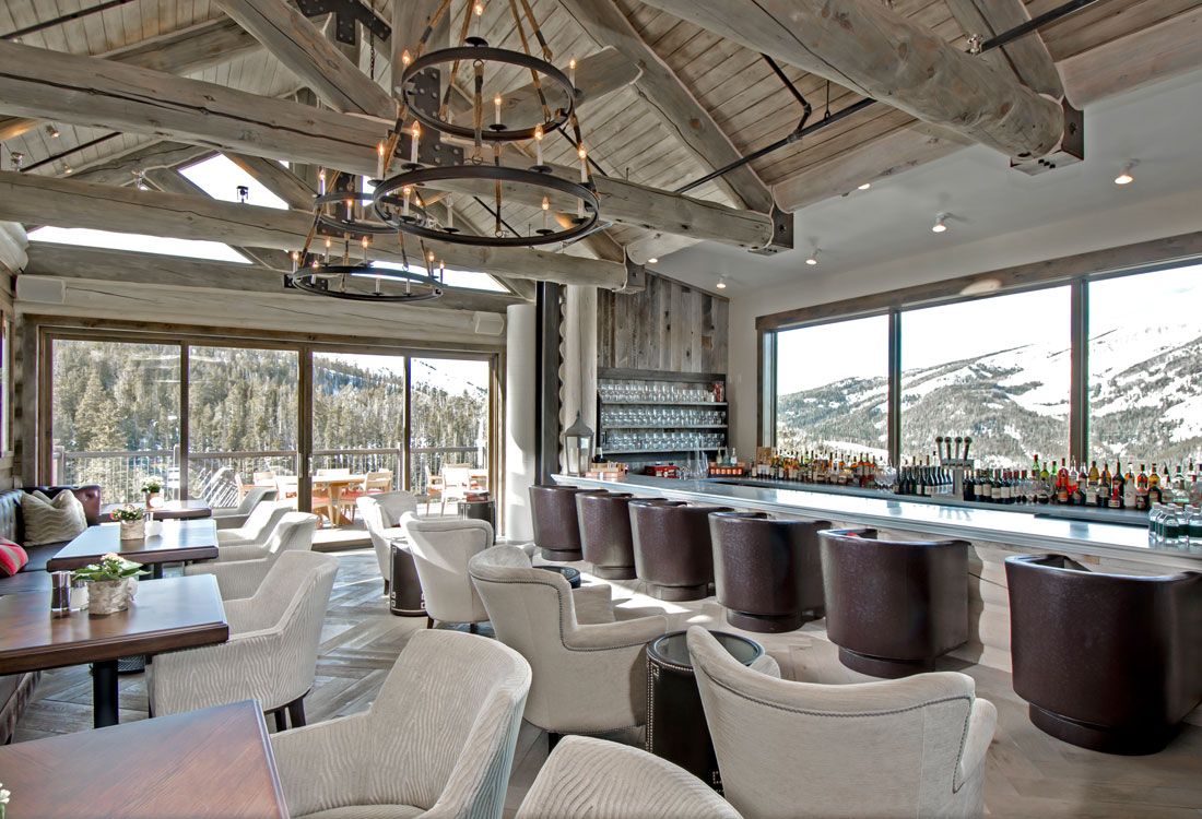 A large room with a bar and chairs in it