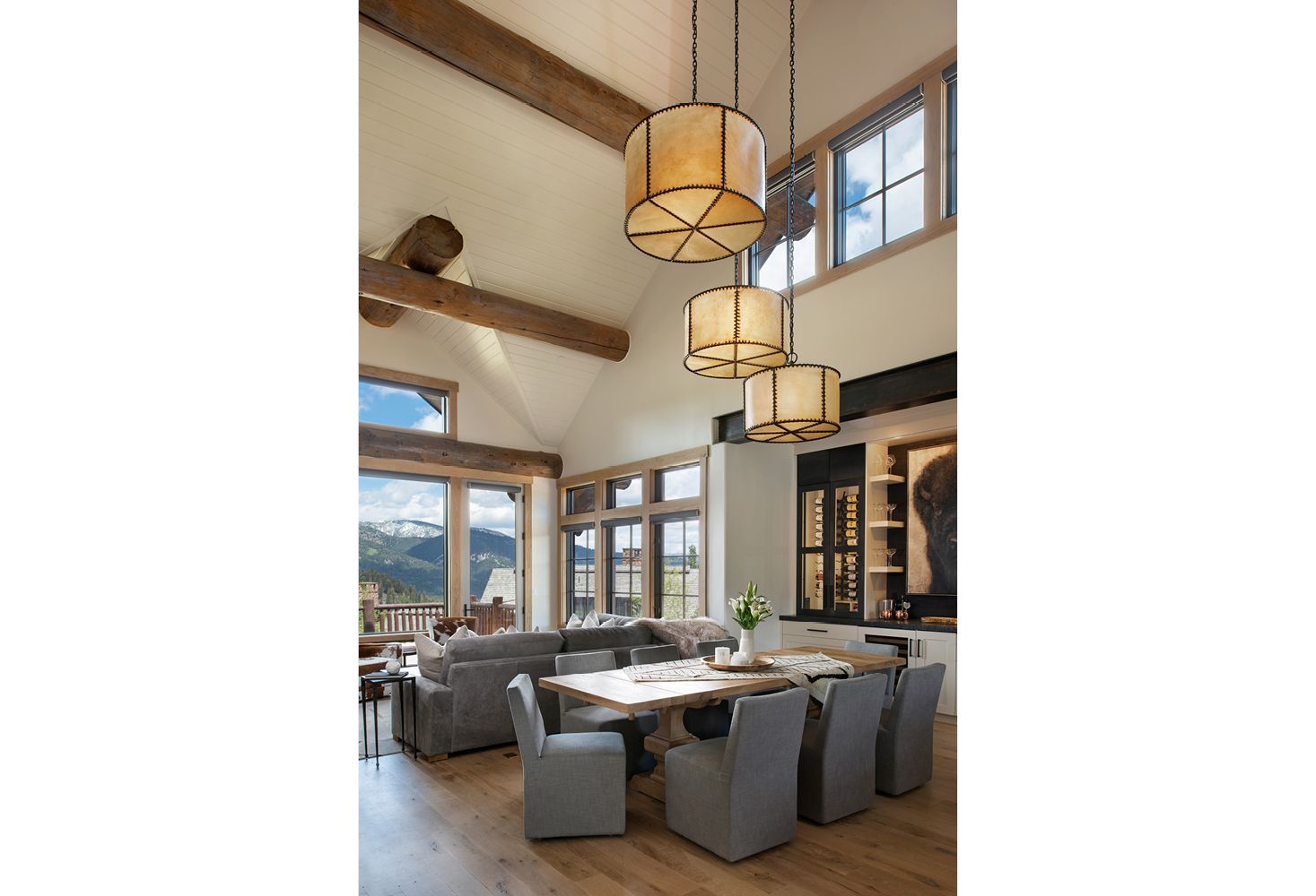A living room with a table and chairs and a chandelier hanging from the ceiling.