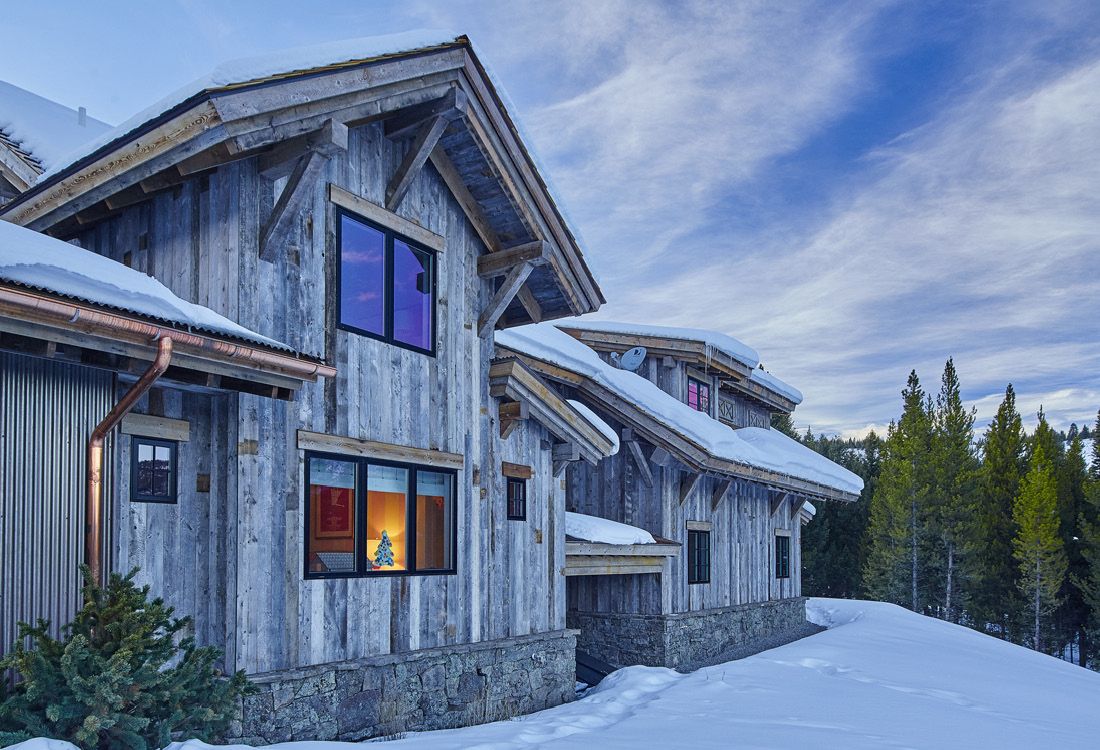 A large house with a lot of windows is covered in snow.