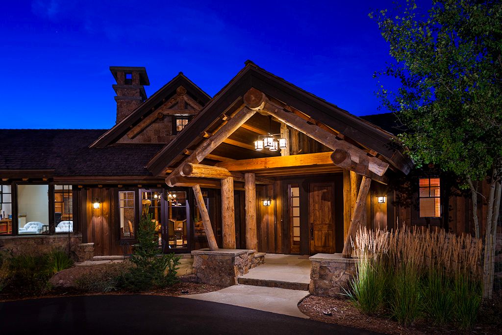 A large log cabin is lit up at night.