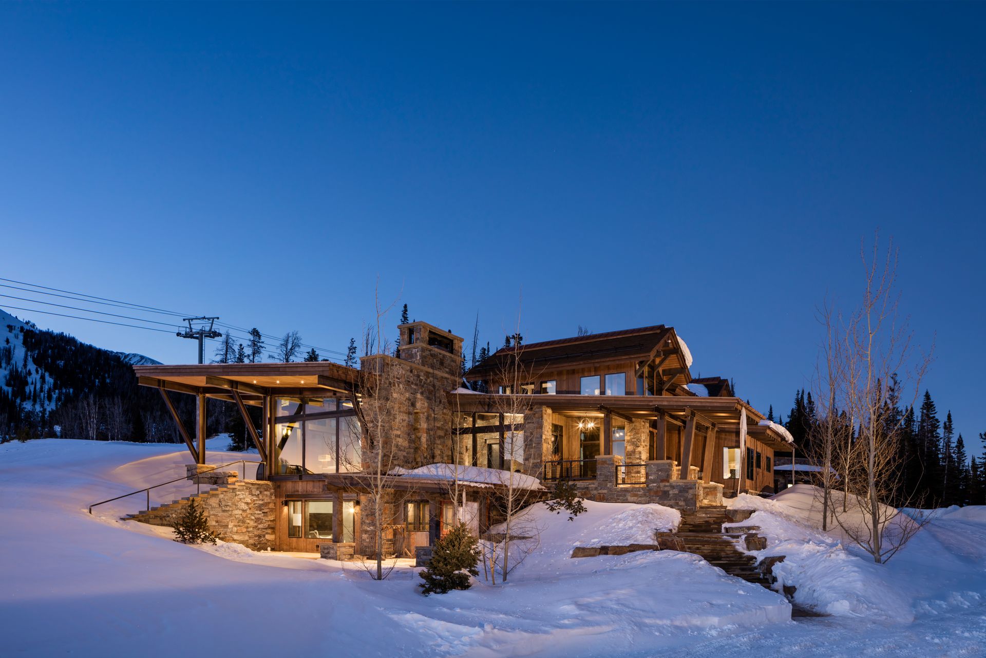 A large house is sitting in the middle of a snow covered field.