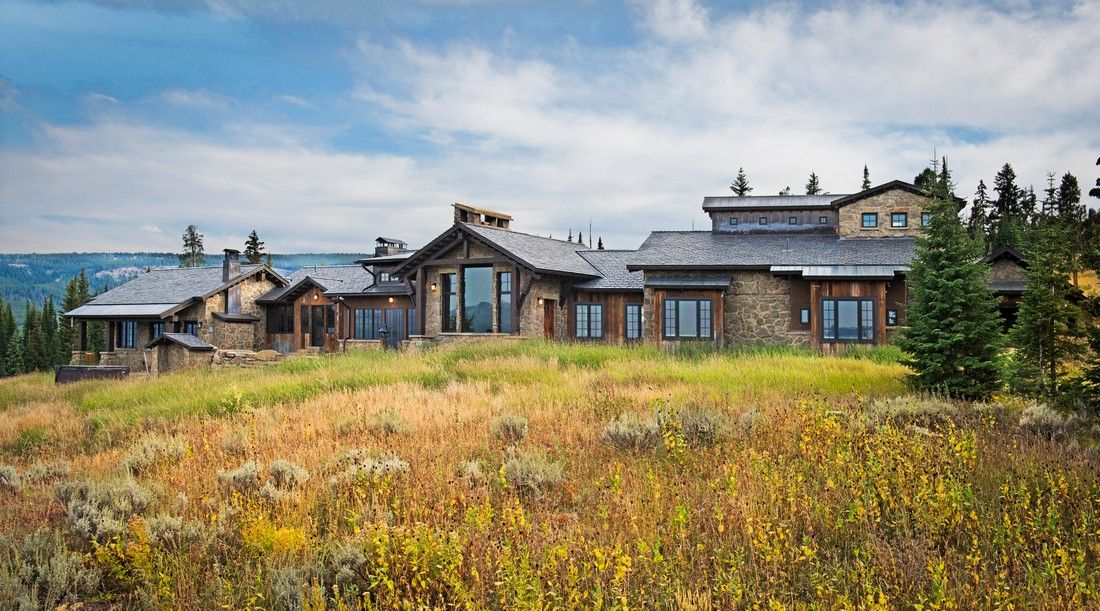 A large house is sitting on top of a grassy hill.