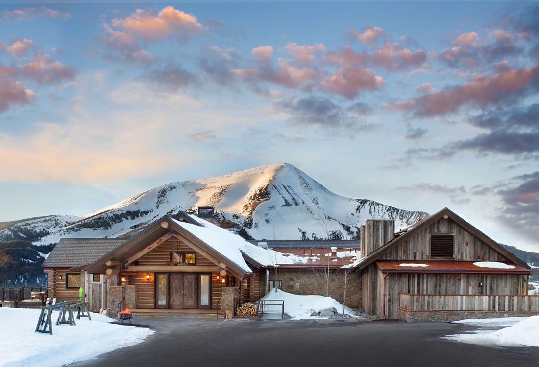 A house in the snow with a mountain in the background