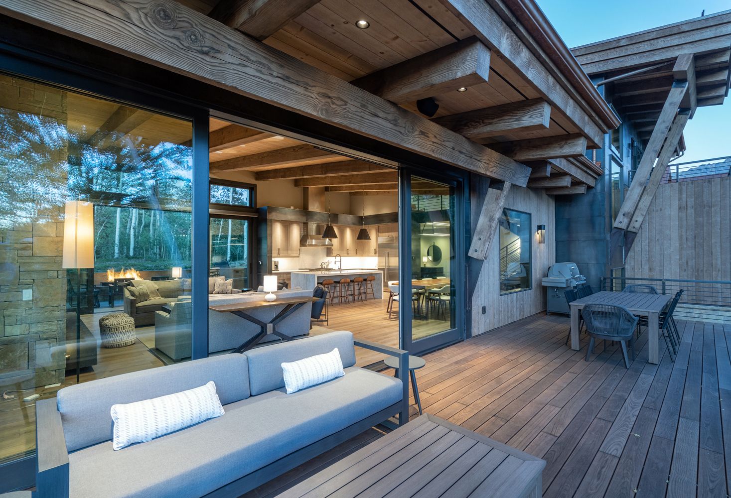 There is a couch and a table on the deck of a house.