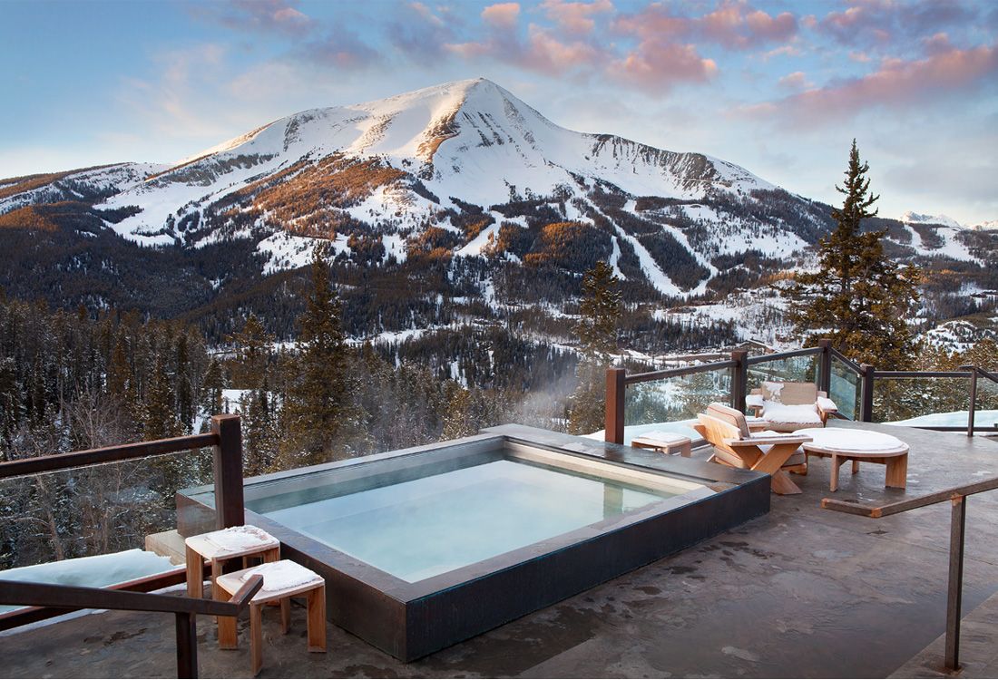 A hot tub with a view of a snowy mountain.