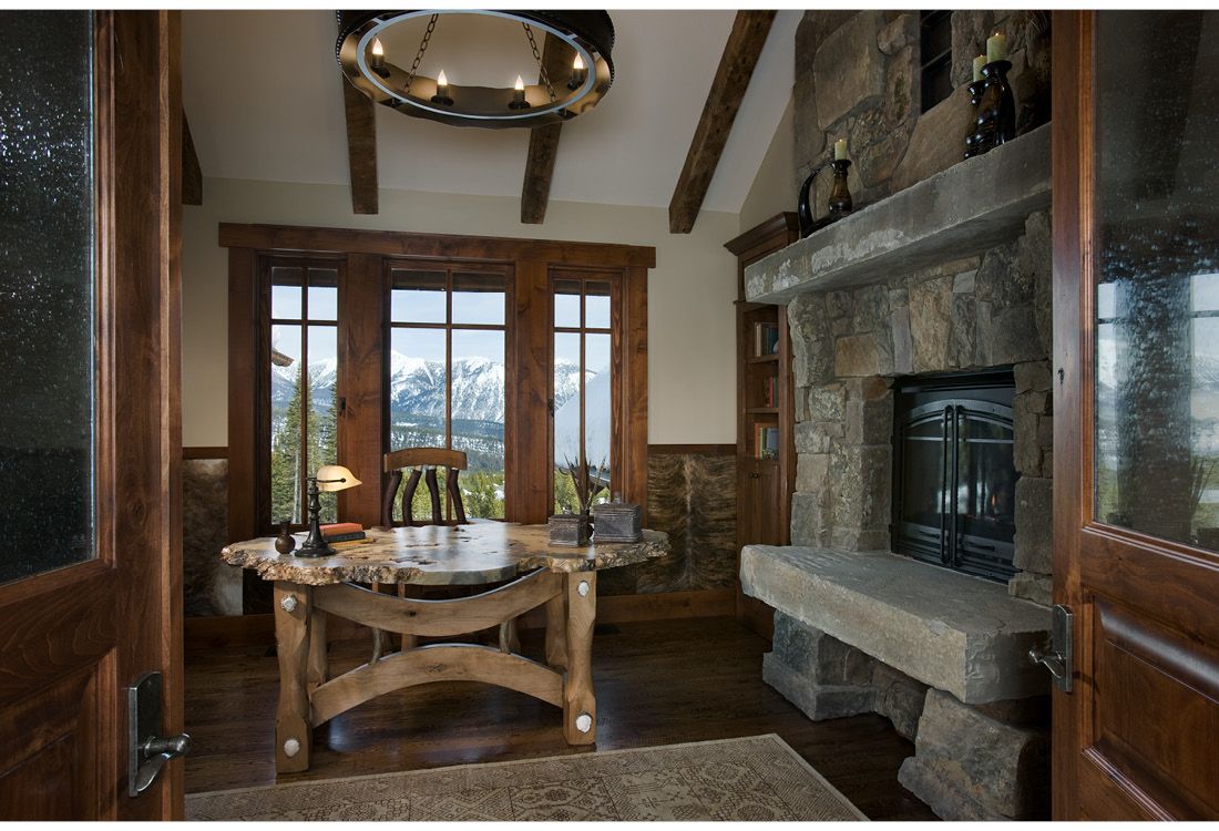 A home office with a desk and a fireplace