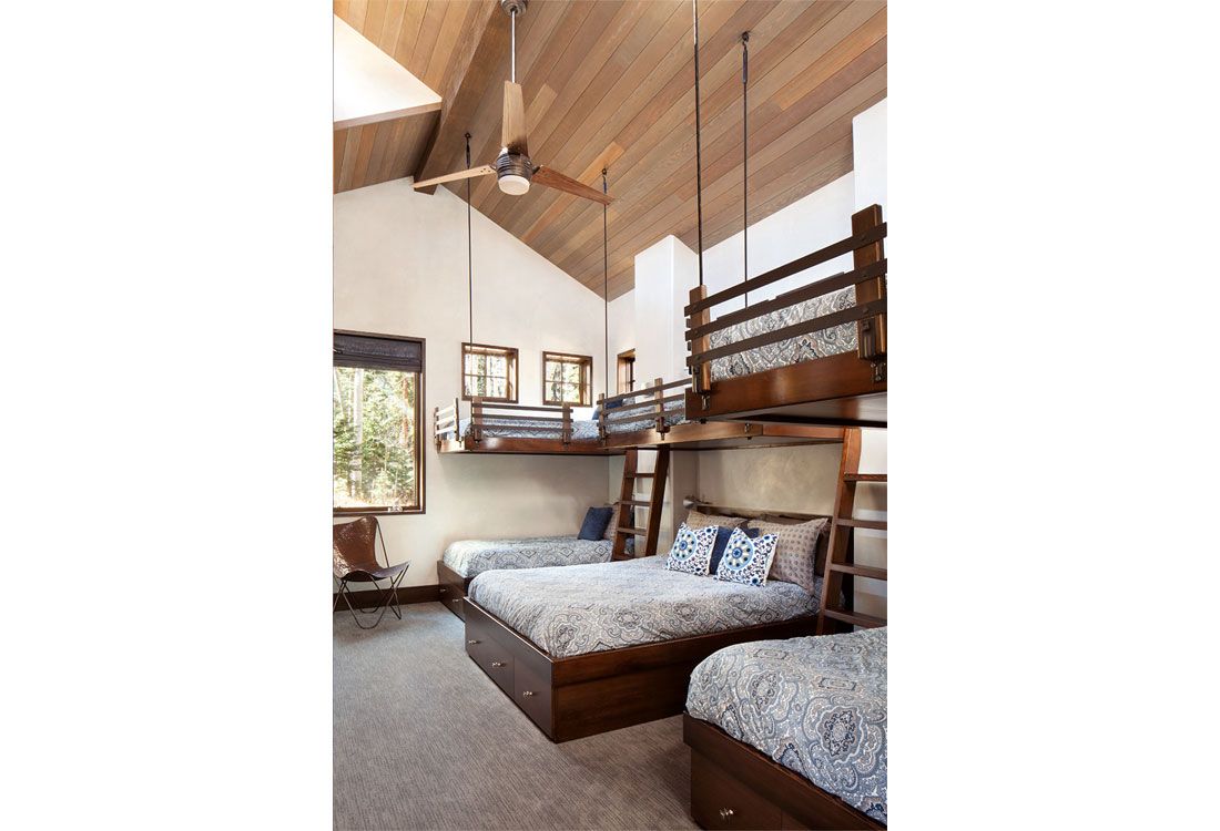 A bedroom with three bunk beds and a ceiling fan.