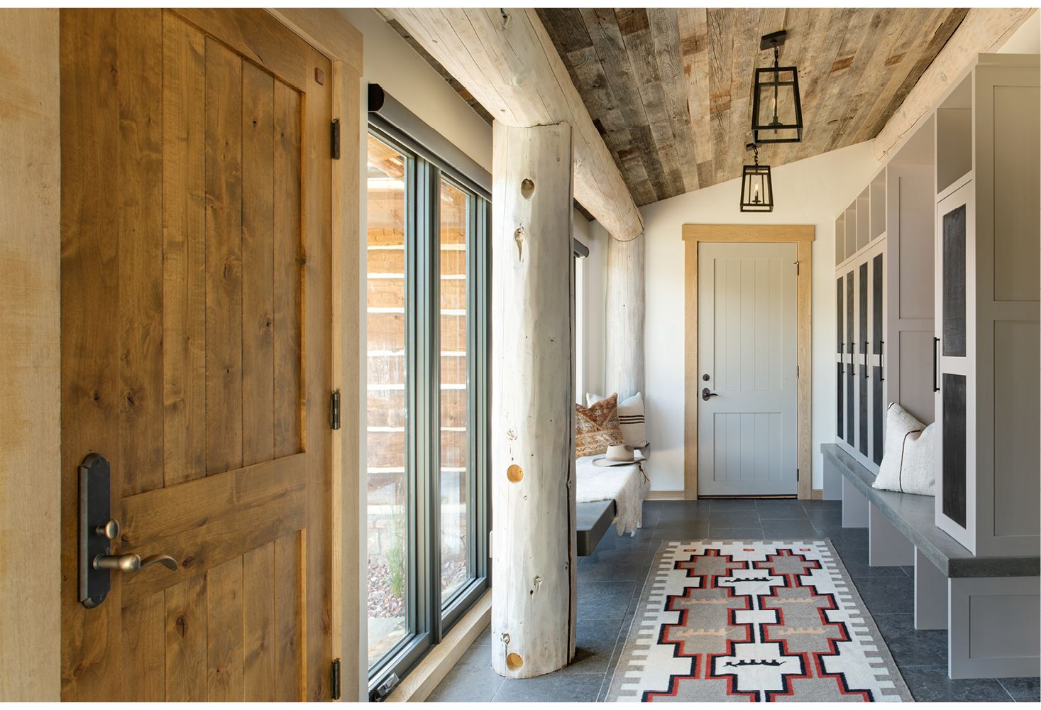 A hallway in a house with wooden doors and a rug.