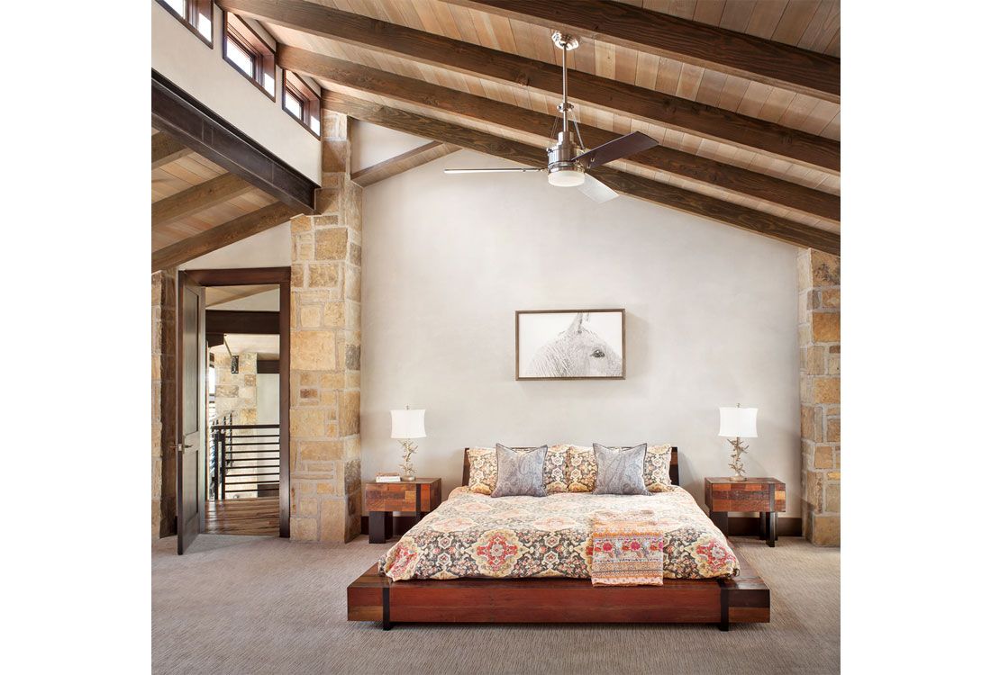 A bedroom with a large bed and a ceiling fan.