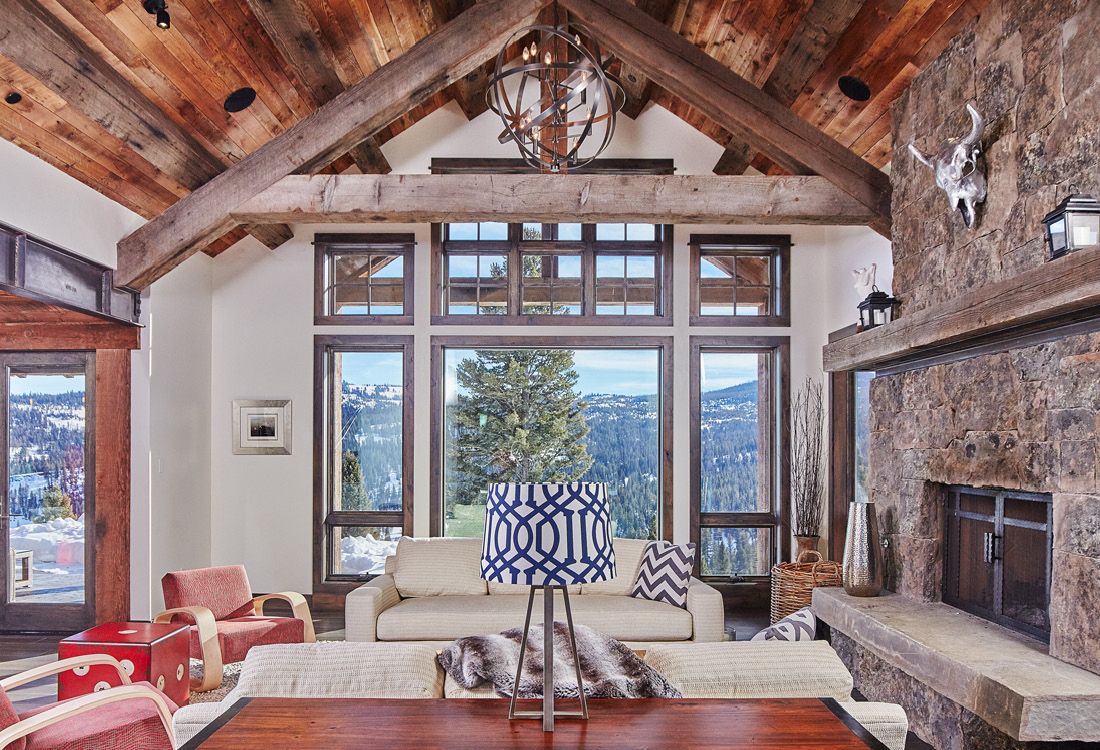 A living room with a couch , fireplace , and lots of windows.
