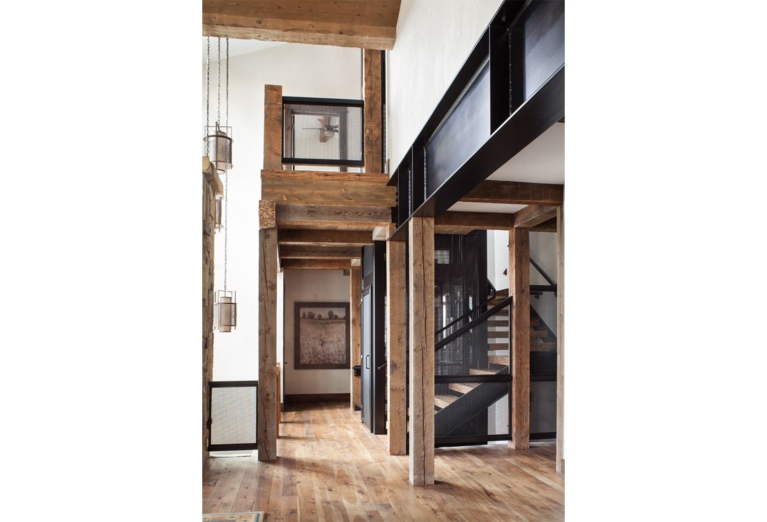 A hallway with wooden beams and a staircase in a house.