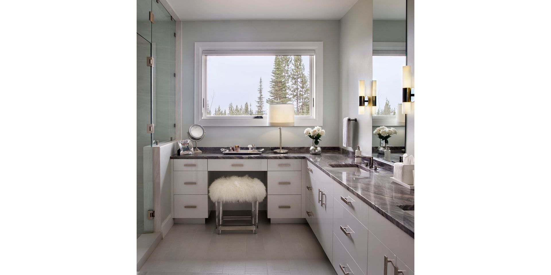 A bathroom with two sinks , a mirror and a window.