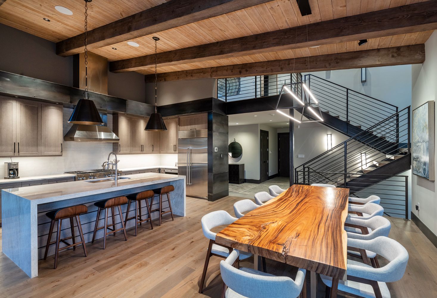 A kitchen and dining room in a house with a large wooden table and chairs.