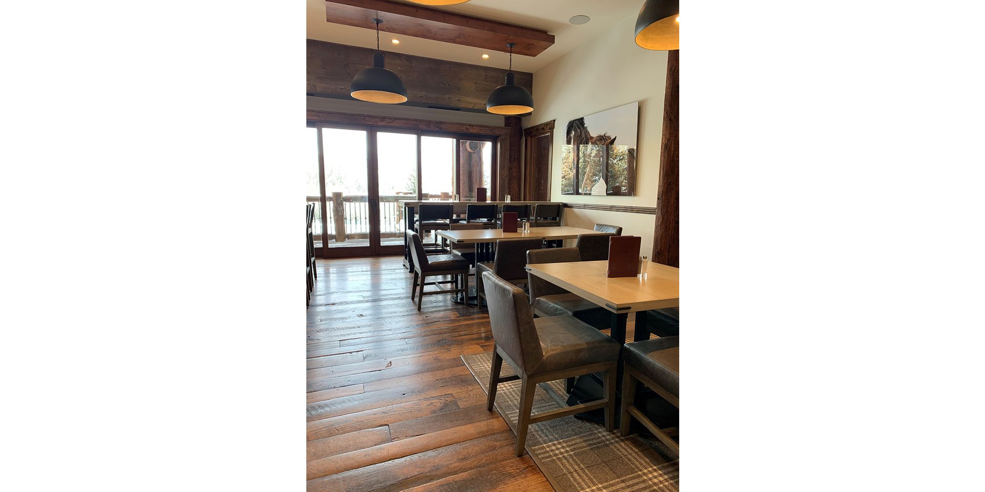 A restaurant with tables and chairs and a large window.