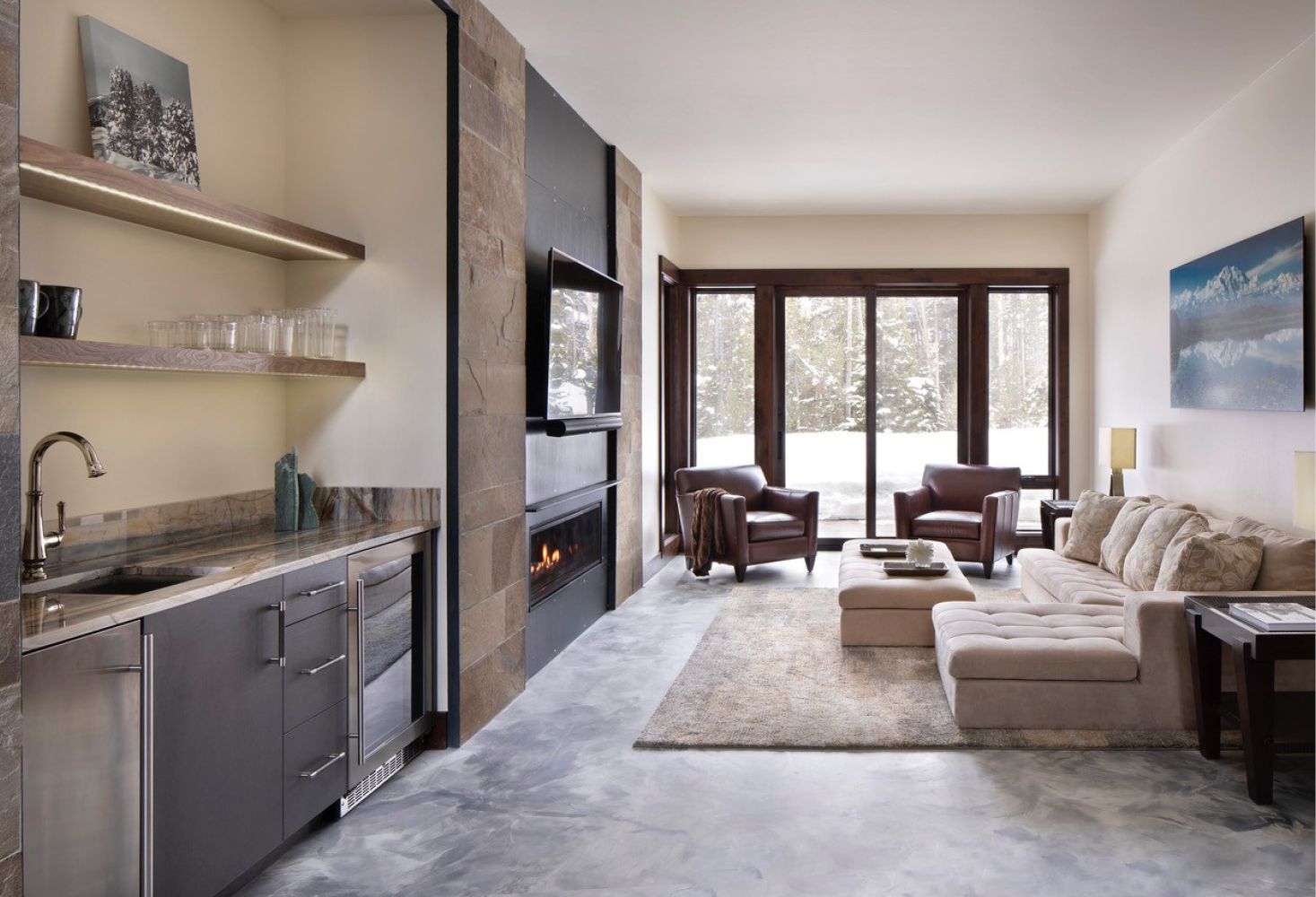 A living room with a couch , chairs , a fireplace and a bar.