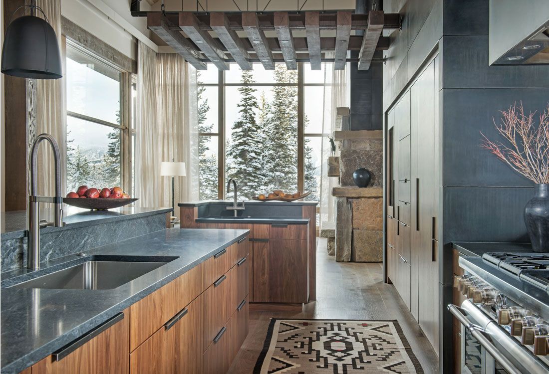 A kitchen with a sink , stove , refrigerator , and large windows.
