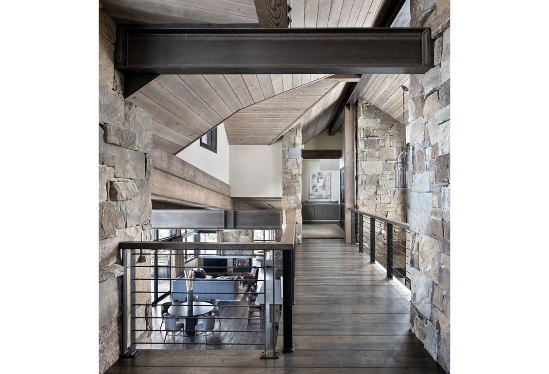 A hallway in a house with a staircase and a railing.