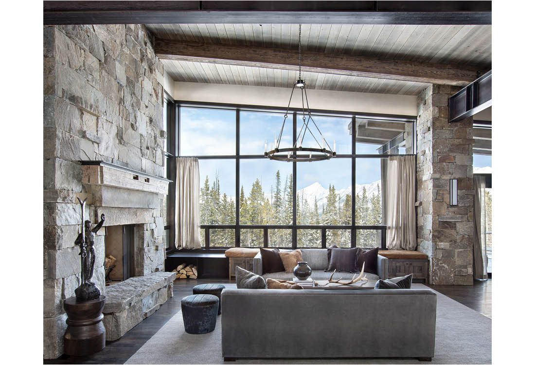 A living room with a couch , fireplace , and large windows.