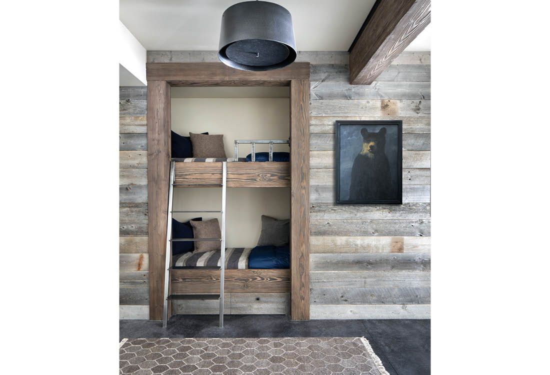 A bedroom with bunk beds and a ladder in a closet.