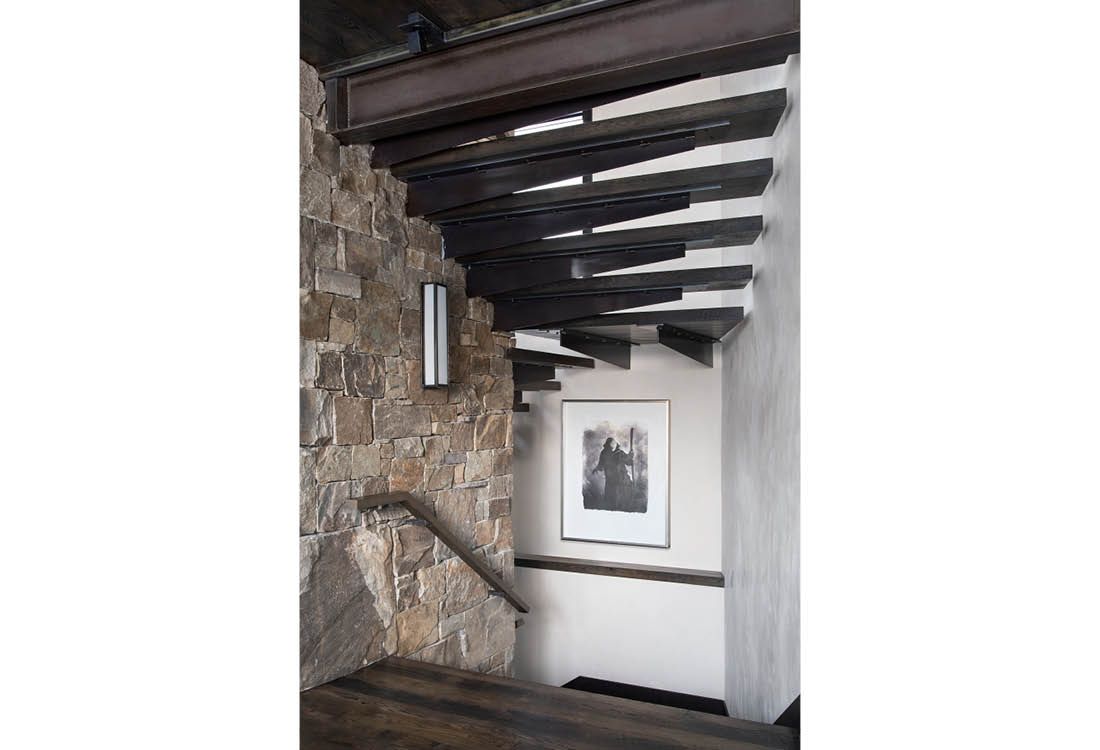 A staircase with wooden beams and a picture on the wall.
