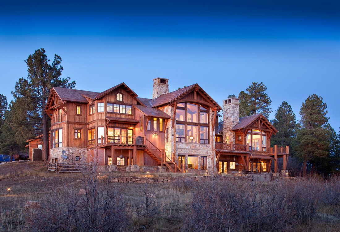 A large house is sitting on top of a hill in the middle of a field.