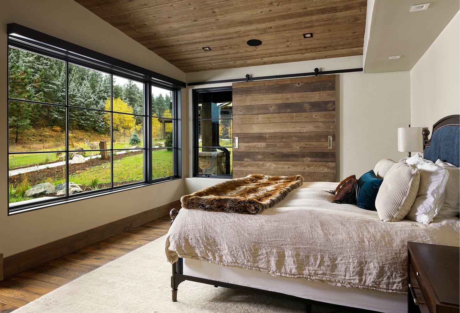 A bedroom with a bed and a sliding barn door.