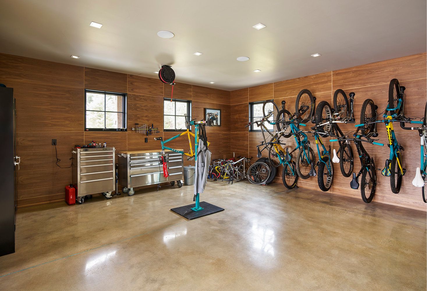 A garage filled with lots of bicycles hanging on the wall.